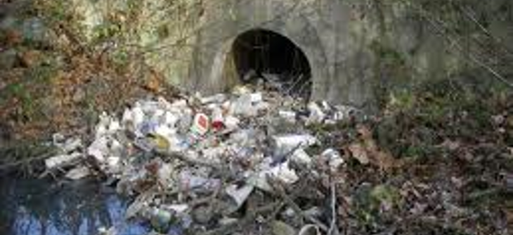 A stormwater outlet filled with trash.