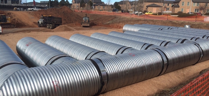 A corrugated metal pipe stormwater detention system is under construction.